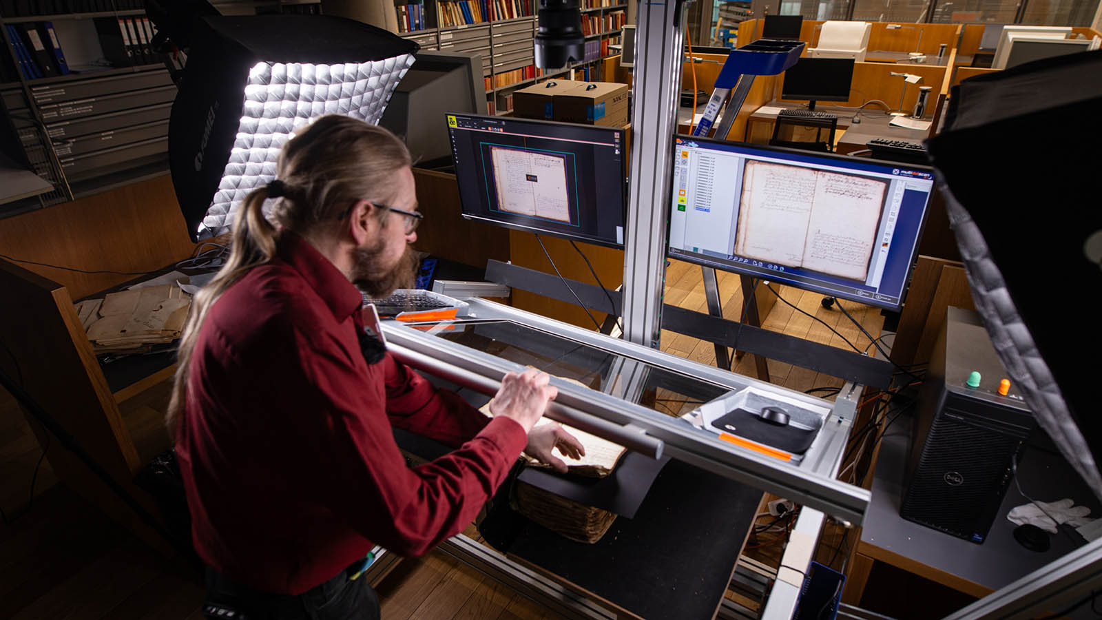 Ylitarkastaja Juho Mattila digitoi aineistoa kamerapöydällä digitaalista toimitusta varten.